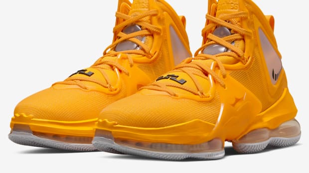 Side view of yellow and black Nike LeBron shoes.